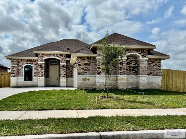 1521 Stirrup Cir, San Benito, TX 78586 - french country inspired facade featuring roof with shingles, a garage, and brick siding