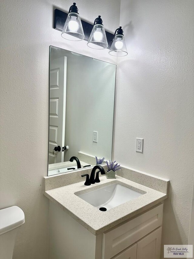 1521 Stirrup Cir, San Benito, TX 78586 - half bathroom with vanity and toilet