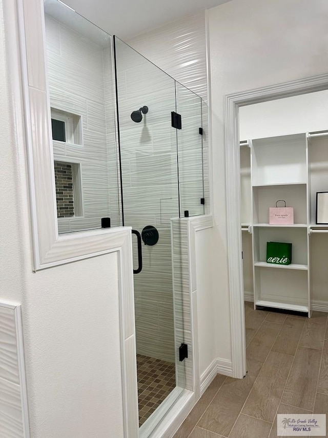 1521 Stirrup Cir, San Benito, TX 78586 - bathroom with a stall shower and wood finished floors