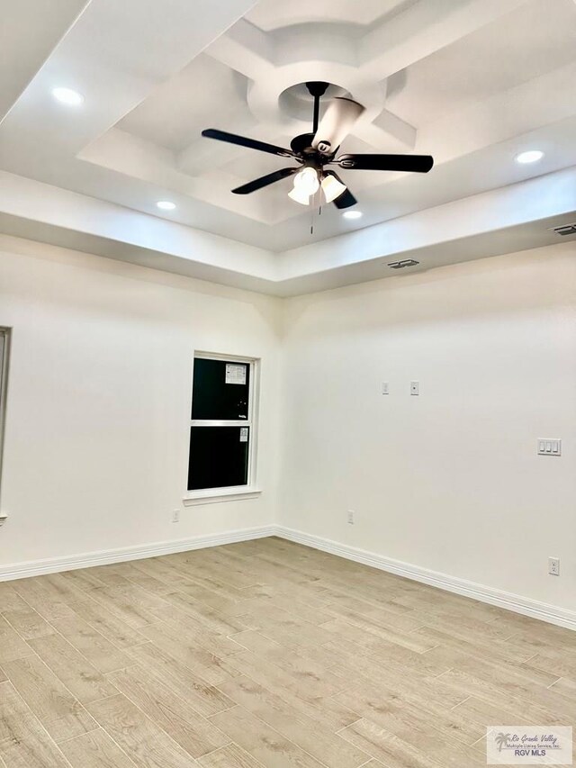 1521 Stirrup Cir, San Benito, TX 78586 - unfurnished room with light wood finished floors, a ceiling fan, a tray ceiling, recessed lighting, and baseboards