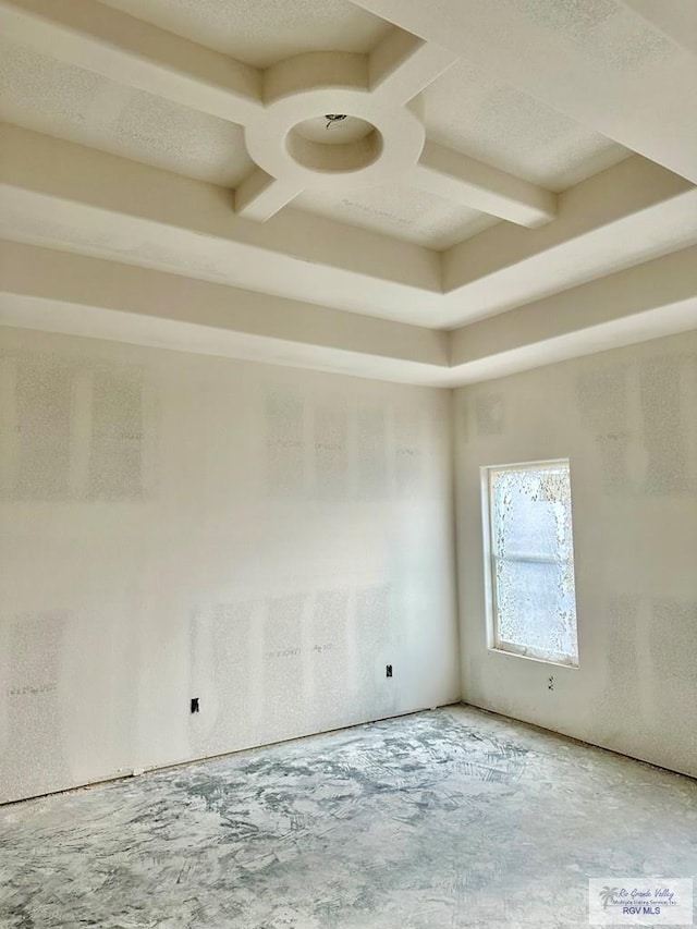 empty room with coffered ceiling and a textured ceiling