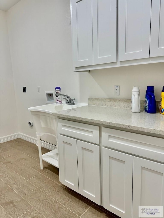 1521 Stirrup Cir, San Benito, TX 78586 - washroom with washer hookup, hookup for an electric dryer, cabinet space, baseboards, and gas dryer hookup