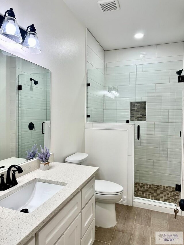 1521 Stirrup Cir, San Benito, TX 78586 - full bathroom with toilet, vanity, a stall shower, and recessed lighting