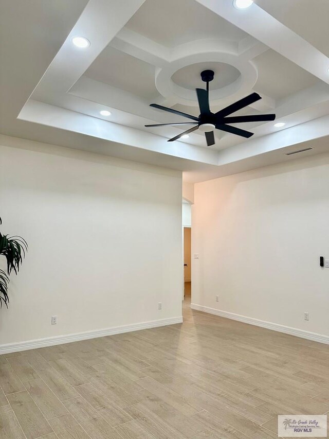 1521 Stirrup Cir, San Benito, TX 78586 - spare room with coffered ceiling, light wood-style floors, a ceiling fan, a raised ceiling, and recessed lighting