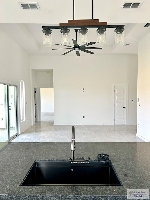 kitchen featuring sink, a towering ceiling, and ceiling fan