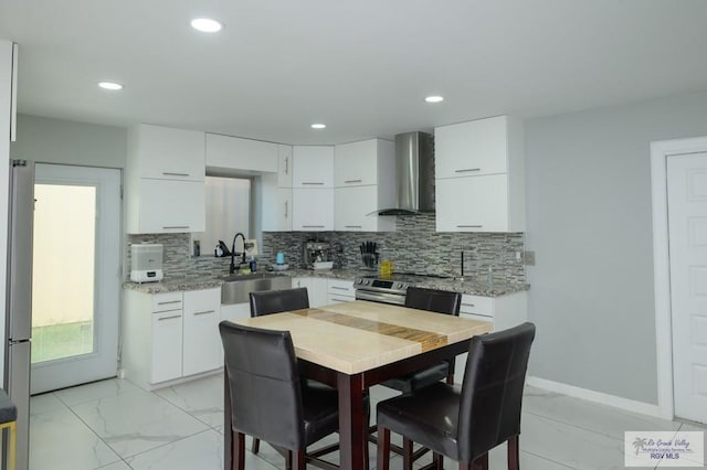 kitchen with white cabinetry, wall chimney exhaust hood, and sink