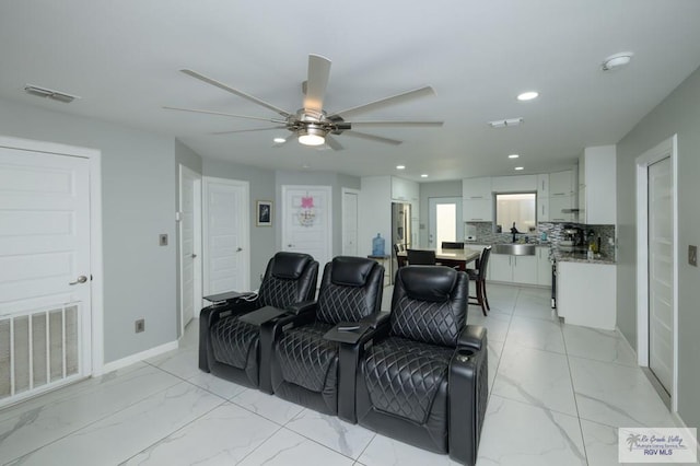 cinema room featuring ceiling fan and sink