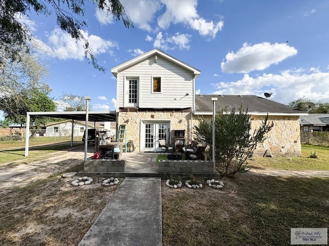 back of house with french doors and a carport