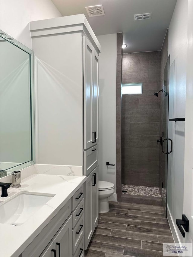 3518 Treasure Hills Blvd, Harlingen, TX 78550 - bathroom with double vanity, a shower stall, and wood tiled floors