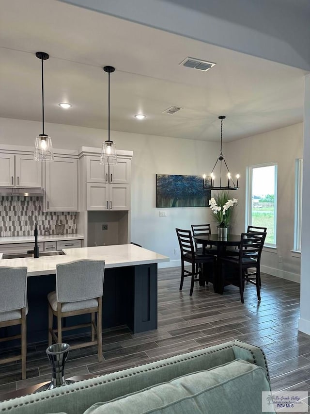 3518 Treasure Hills Blvd, Harlingen, TX 78550 - kitchen featuring light countertops, tasteful backsplash, dark wood-type flooring, a chandelier, and pendant lighting
