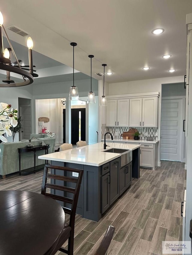 3518 Treasure Hills Blvd, Harlingen, TX 78550 - kitchen with light countertops, recessed lighting, white cabinetry, a center island with sink, and backsplash