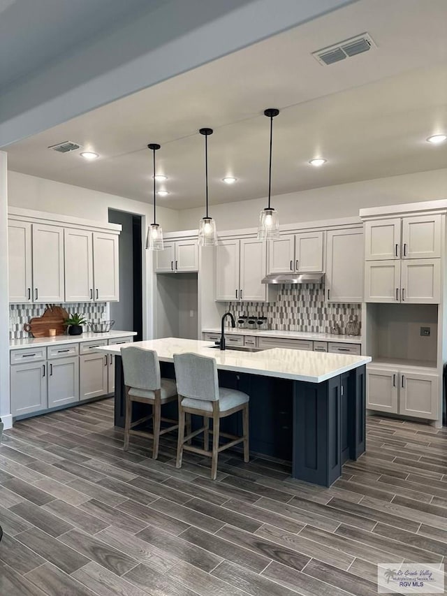 3518 Treasure Hills Blvd, Harlingen, TX 78550 - kitchen with dark wood-style floors, a spacious island, decorative backsplash, light countertops, and recessed lighting