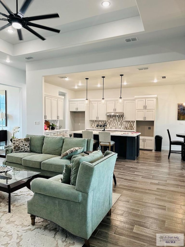 3518 Treasure Hills Blvd, Harlingen, TX 78550 - living area with a tray ceiling, ceiling fan, recessed lighting, and wood finished floors