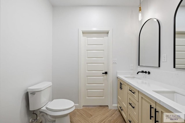 bathroom featuring vanity, toilet, and parquet floors