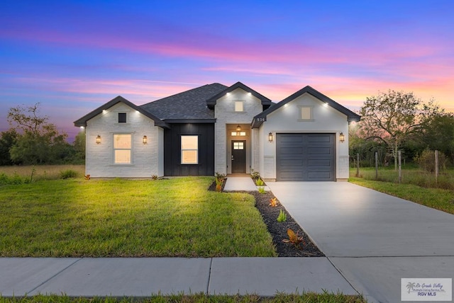 modern farmhouse style home with a lawn and a garage