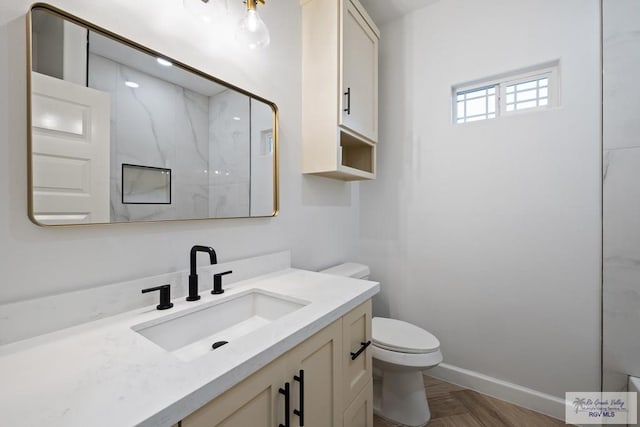 bathroom featuring a shower, vanity, parquet flooring, and toilet