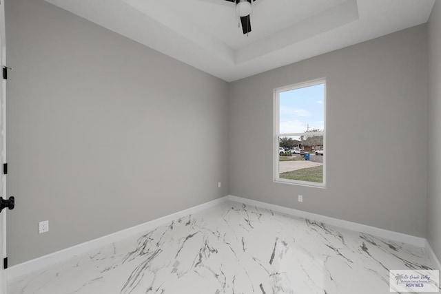 unfurnished room featuring ceiling fan and a tray ceiling