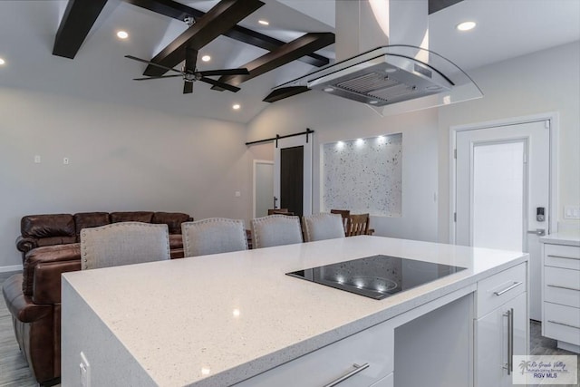 kitchen with white cabinetry, a barn door, island exhaust hood, wood-type flooring, and black electric cooktop