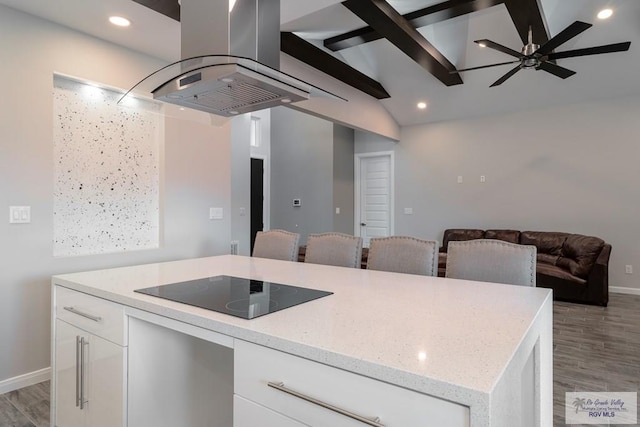 kitchen featuring black electric stovetop, light stone countertops, white cabinetry, and island exhaust hood