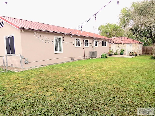 back of property featuring a yard and central AC