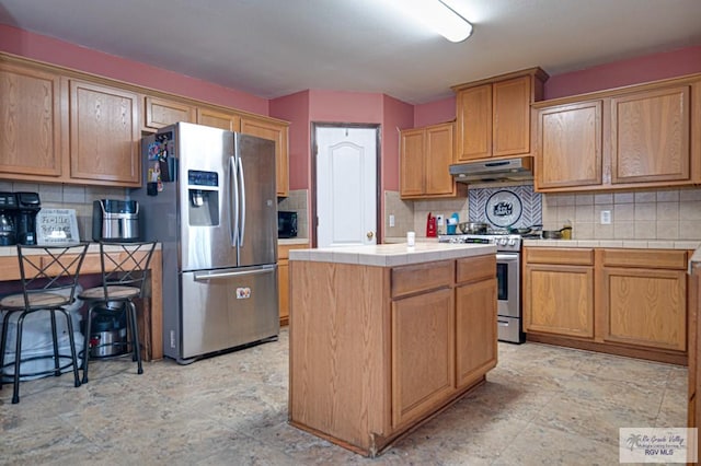 kitchen featuring tasteful backsplash, appliances with stainless steel finishes, and a kitchen island