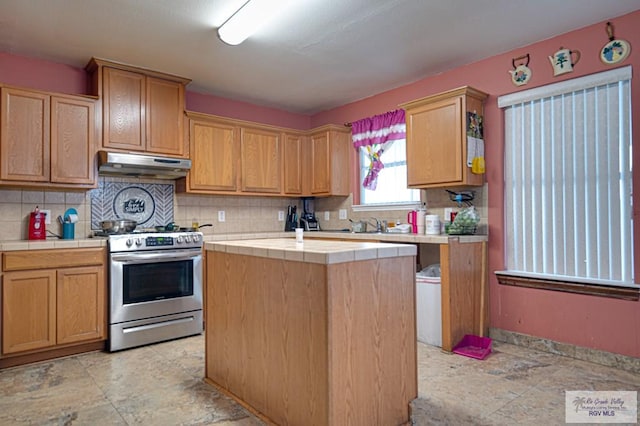 kitchen with tasteful backsplash, stainless steel electric range, tile countertops, and a kitchen island