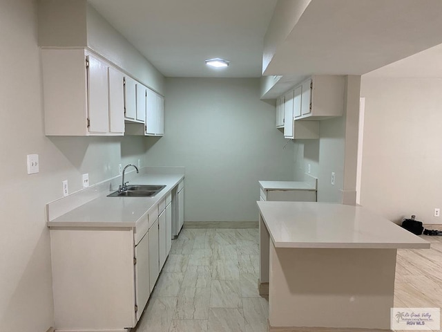 2304 Shidler Dr Unit 10-40, Brownsville, TX 78521 - kitchen featuring light marble finish floors, light countertops, white cabinets, and a peninsula