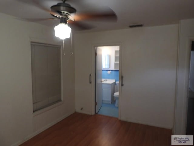 55 Carlton Dr, Brownsville, TX 78521 - unfurnished bedroom featuring wood finished floors, connected bathroom, and ceiling fan