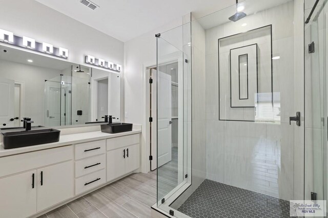 516 Eagle Dr, Los Fresnos, TX 78566 - bathroom with visible vents, a sink, a shower stall, and double vanity