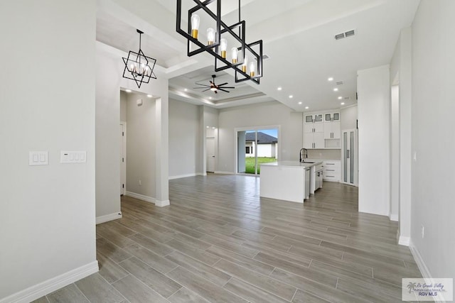 516 Eagle Dr, Los Fresnos, TX 78566 - interior space with visible vents, a sink, light wood-type flooring, baseboards, and ceiling fan with notable chandelier