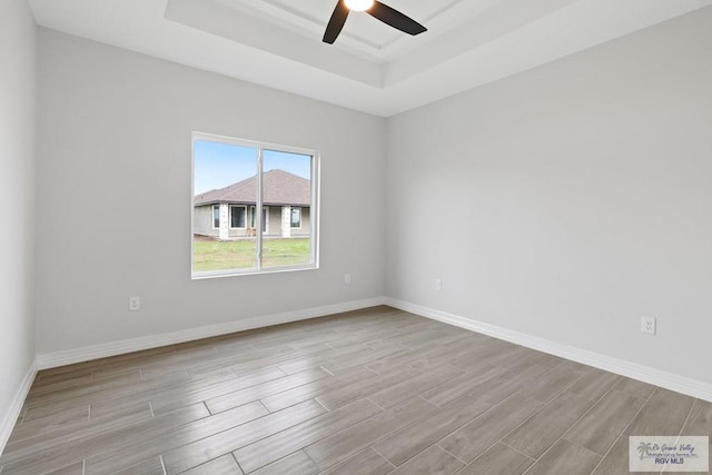 516 Eagle Dr, Los Fresnos, TX 78566 - spare room with a ceiling fan, baseboards, wood finish floors, and a raised ceiling