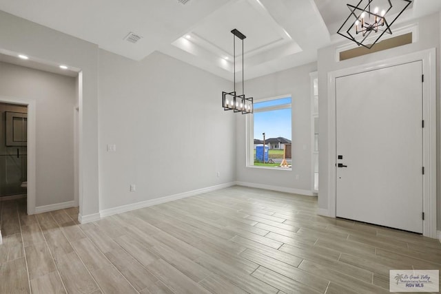 516 Eagle Dr, Los Fresnos, TX 78566 - unfurnished dining area featuring light wood-style flooring, a tray ceiling, visible vents, baseboards, and a notable chandelier