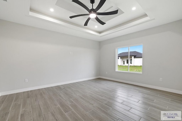 516 Eagle Dr, Los Fresnos, TX 78566 - spare room featuring a ceiling fan, wood finished floors, a tray ceiling, baseboards, and recessed lighting