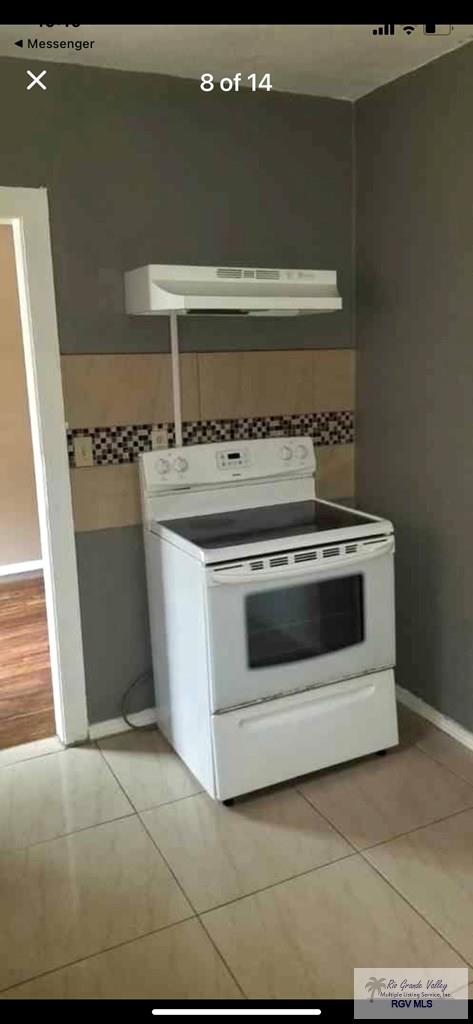 kitchen with light tile patterned flooring and white electric range