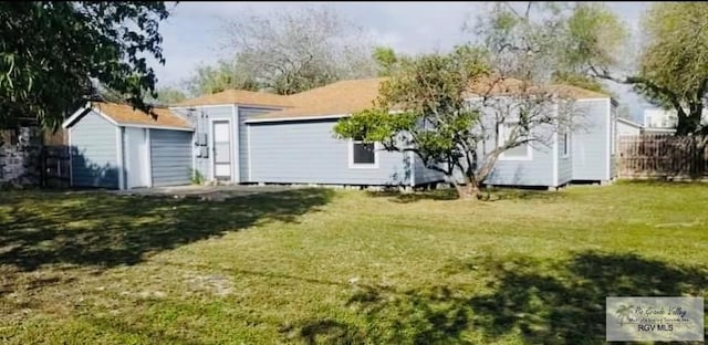 rear view of house featuring a yard and a shed