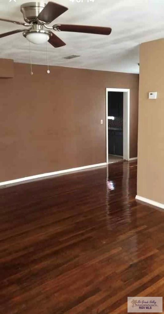 unfurnished room featuring dark hardwood / wood-style floors and ceiling fan