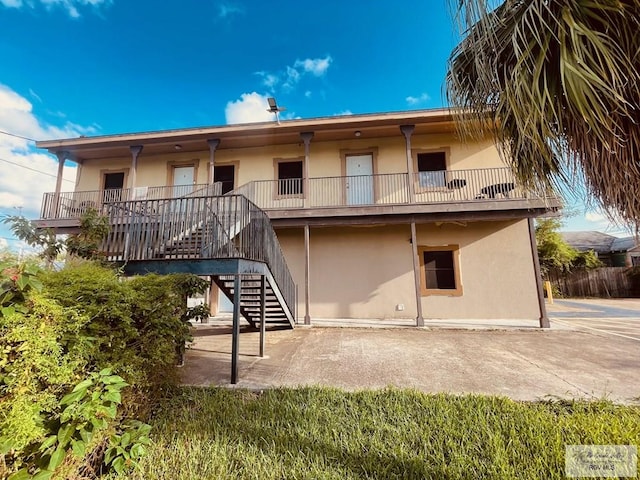 144 N St, Brownsville, TX 78521 - back of property featuring stucco siding, stairway, and a patio