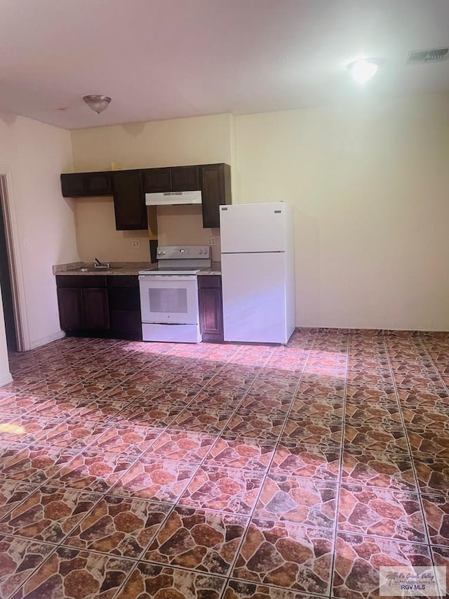 144 N St, Brownsville, TX 78521 - kitchen with white appliances, under cabinet range hood, and dark brown cabinetry