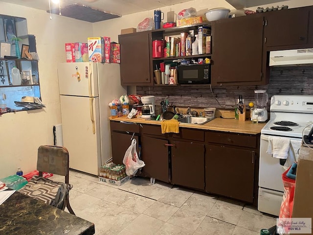 144 N St, Brownsville, TX 78521 - kitchen with under cabinet range hood, white appliances, decorative backsplash, light countertops, and dark brown cabinets