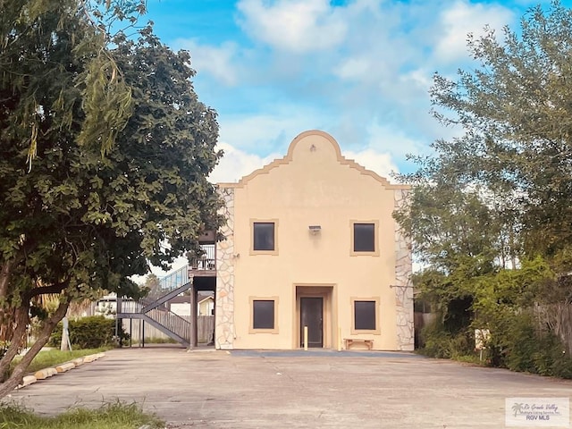 144 N St, Brownsville, TX 78521 - view of front of home with stucco siding and stairway