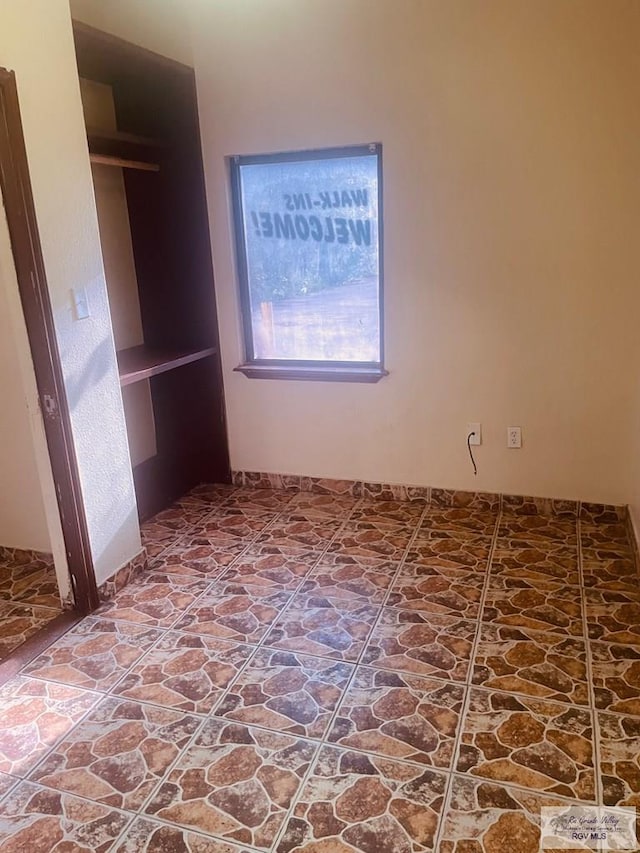 144 N St, Brownsville, TX 78521 - unfurnished bedroom with stone finish floors and a closet