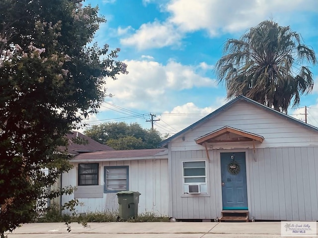 144 N St, Brownsville, TX 78521 - view of front of house featuring cooling unit, entry steps, and a shingled roof