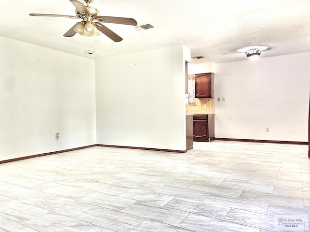 spare room with ceiling fan and a textured ceiling