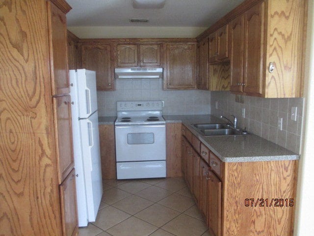 kitchen with light tile patterned floors, white appliances, backsplash, and sink