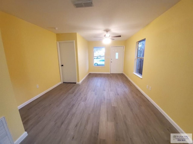 608 W Polk St, Harlingen, TX 78550 - empty room with ceiling fan, visible vents, baseboards, and dark wood-style flooring