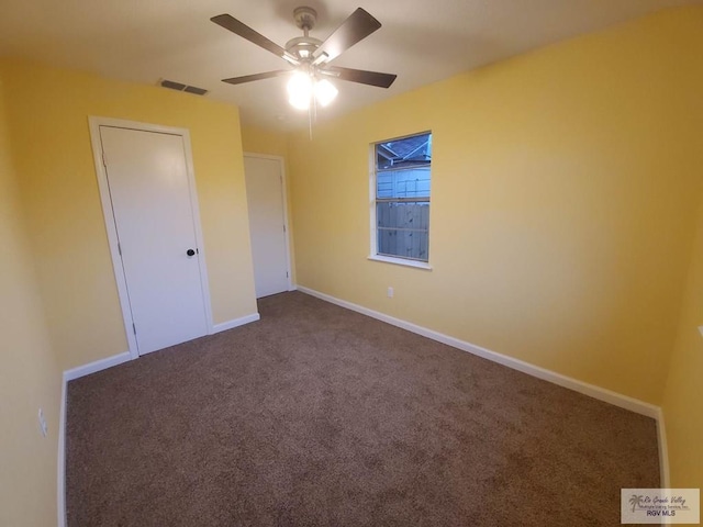 608 W Polk St, Harlingen, TX 78550 - unfurnished bedroom with dark carpet, baseboards, a ceiling fan, and visible vents