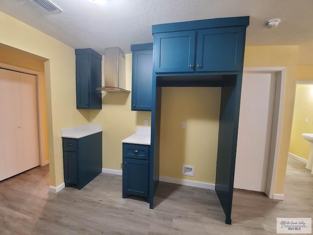 608 W Polk St, Harlingen, TX 78550 - kitchen with light wood-style flooring, visible vents, and blue cabinetry