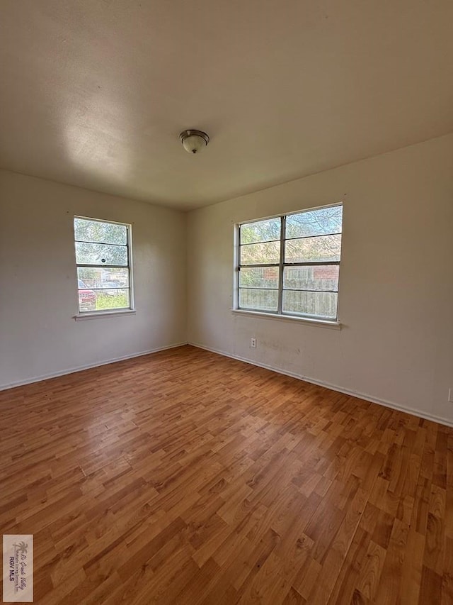 1206 S C St, Harlingen, TX 78550 - unfurnished room featuring wood finished floors and plenty of natural light