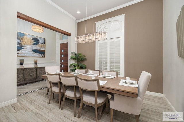 dining area with a chandelier, light hardwood / wood-style floors, and ornamental molding