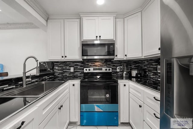 kitchen featuring appliances with stainless steel finishes, tasteful backsplash, white cabinetry, and sink